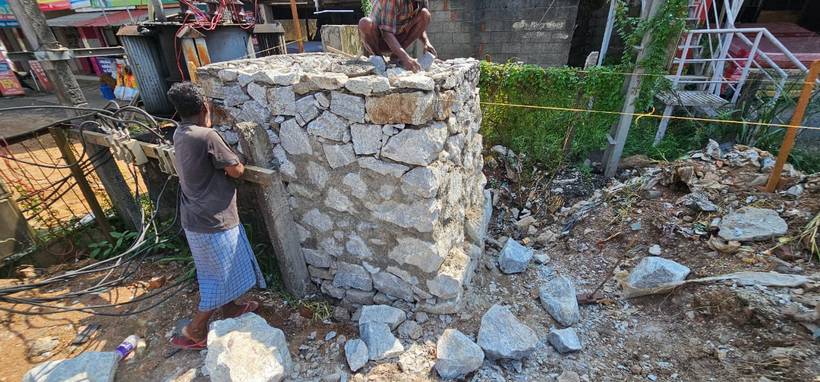 Stone masonry valve chamber under construction beside the road
